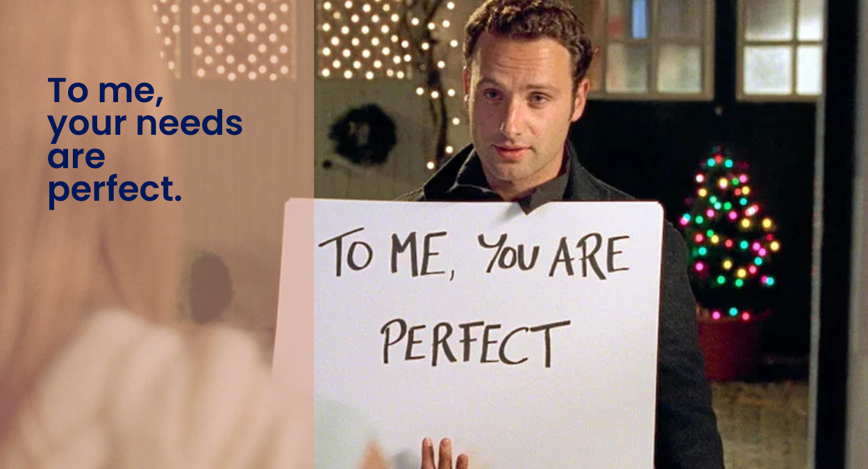 Person holding a handwritten sign in a Love Actually–style moment, with a playful PCM quote about family stress and emotional needs.