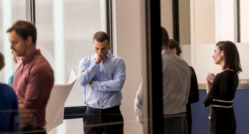 Office workers showing subtle signs of tension and miscommunication in a workplace corridor